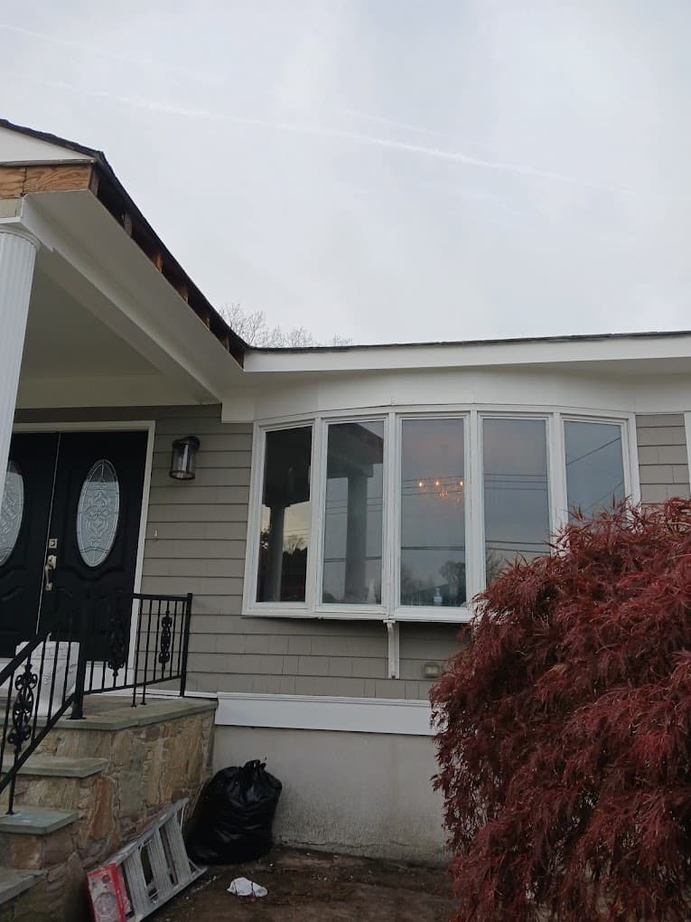 Gray house with bay window exterior painting in Massachusetts - professional house painting