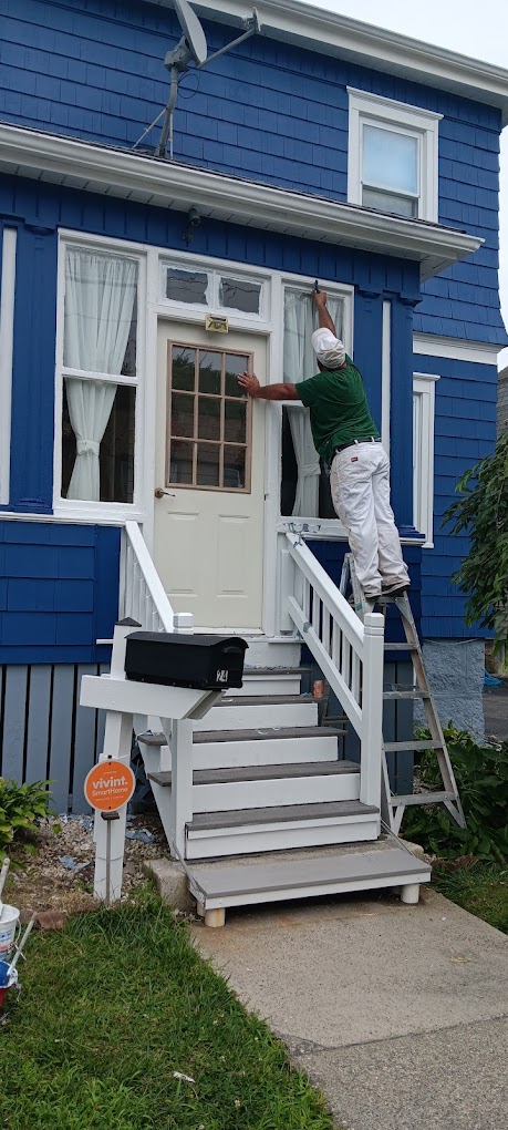 Professional painter working on blue house exterior